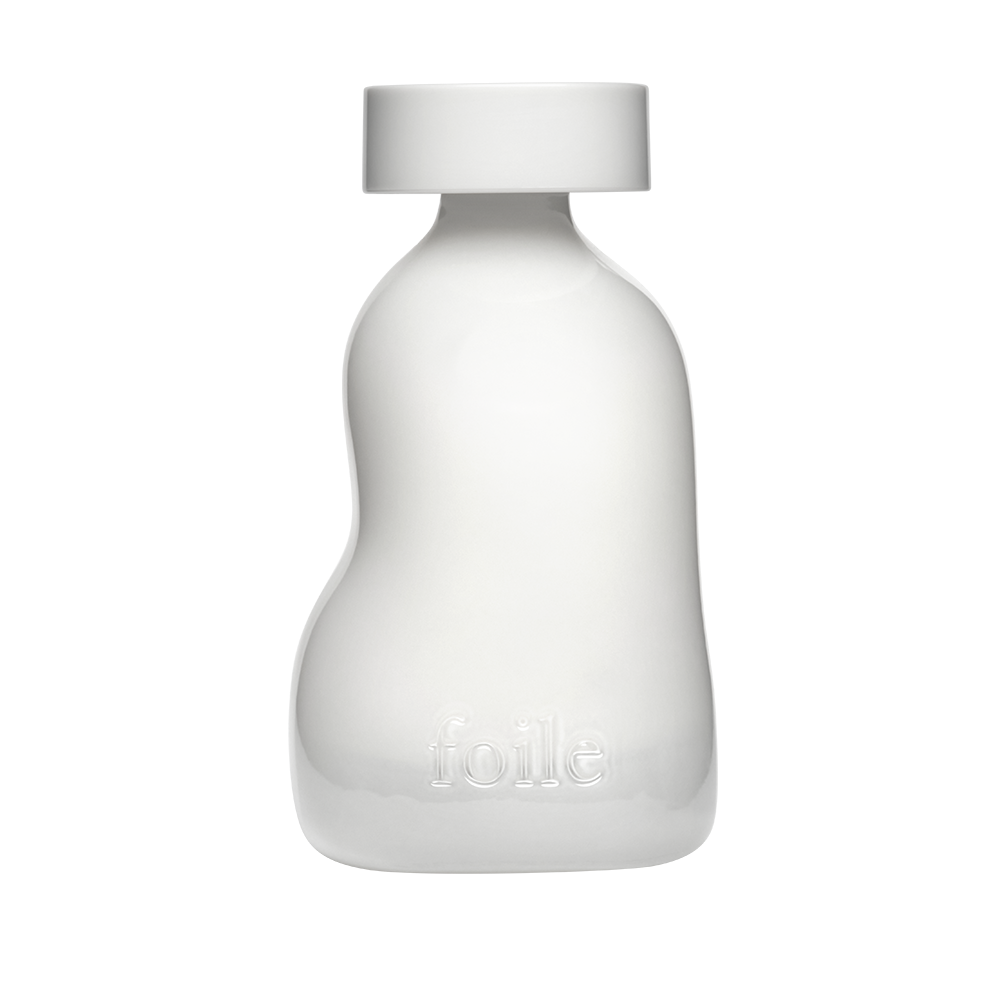 A white pump bottle of facial cleanser against a black background.